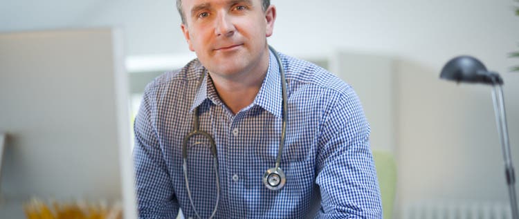 mature doctor looks to camera