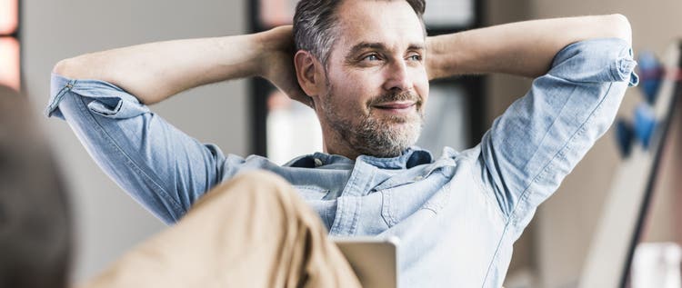 Businessman in office leaning back