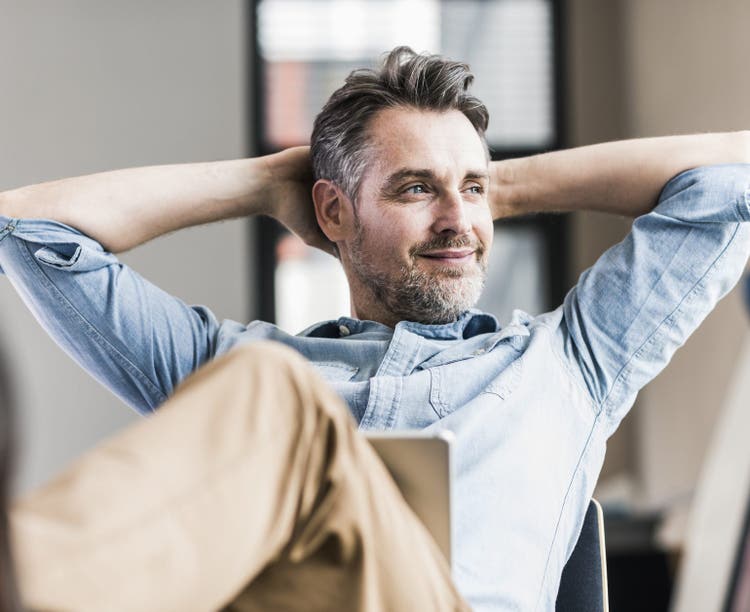 Businessman in office leaning back