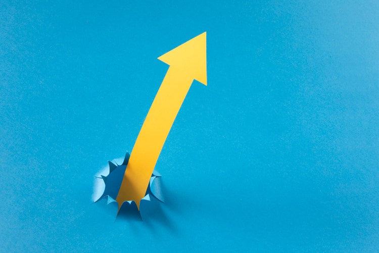 Finance concept with yellow paper arrows on blue background