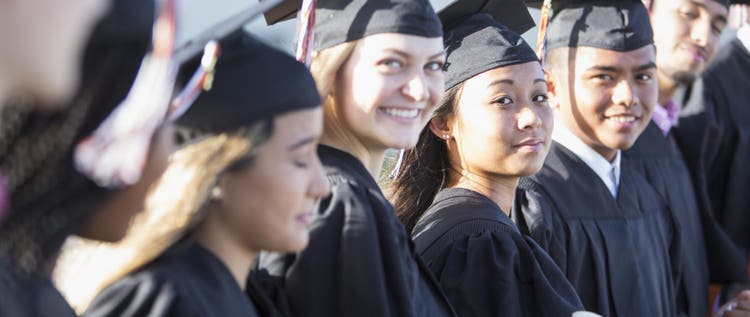 Multi-ethnic teenage graduates in cap and gown