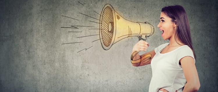 Young woman screaming into loudspeaker