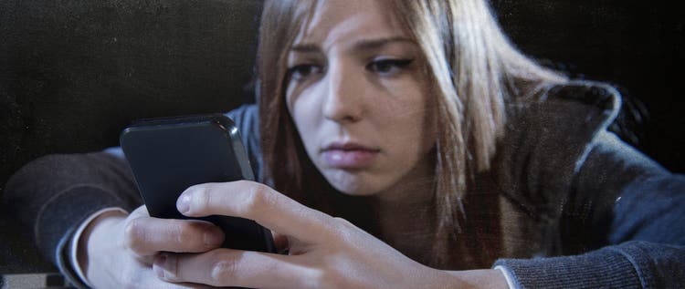 worried woman stares at phone