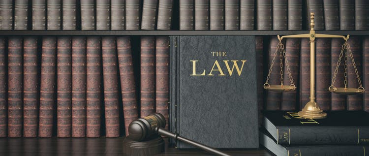 Law bookshelf with wooden judge's gavel and golden scale